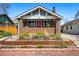 Charming brick home featuring a manicured front yard and a welcoming red front door at 3345 W Clyde Pl, Denver, CO 80211