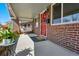 Spacious front porch with a swing and a decorative red front door at 3345 W Clyde Pl, Denver, CO 80211