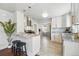 Bright kitchen features white cabinets, granite countertops, stainless steel appliances, and a breakfast bar with pendant lighting at 3345 W Clyde Pl, Denver, CO 80211
