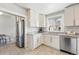 Kitchen close-up with granite countertops, stainless steel appliances, and white cabinets at 3345 W Clyde Pl, Denver, CO 80211