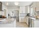 Bright, stylish kitchen featuring white cabinets, granite countertops, stainless steel appliances, and an open layout at 3345 W Clyde Pl, Denver, CO 80211