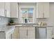Close-up of kitchen featuring granite countertops, tile backsplash, stainless steel sink, and stainless steel dishwasher at 3345 W Clyde Pl, Denver, CO 80211