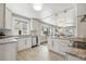 Bright, open kitchen featuring granite countertops, stainless steel appliances, and white cabinets at 3345 W Clyde Pl, Denver, CO 80211