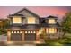 Home exterior featuring a brick facade, two-car garage, covered porch, and well-lit windows at twilight at 3055 E 133Rd Cir, Thornton, CO 80241