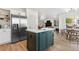 Open kitchen with a central island, stainless steel refrigerator, and seamless flow into the living area at 3055 E 133Rd Cir, Thornton, CO 80241