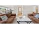 Open-concept living space with hardwood floors, comfortable sofas, and view of the updated kitchen at 3055 E 133Rd Cir, Thornton, CO 80241