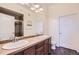 Bathroom featuring double sinks, a large mirror, and a tiled shower with a glass door at 10111 Inverness Main St # 228, Englewood, CO 80112