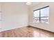 Well-lit bedroom showcasing beautiful hardwood floors and a large window with neighborhood views at 10111 Inverness Main St # 228, Englewood, CO 80112