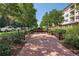 A common green with benches lined along the walkway among grass, plants, and neighboring buildings at 10111 Inverness Main St # 228, Englewood, CO 80112