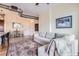 Comfortable living room with a neutral colored sofa, accent rug, and a view into the dining area at 10111 Inverness Main St # 228, Englewood, CO 80112