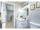 Bathroom with a white vanity, updated fixtures, and decor; open door to bedroom at 2921 E Colorado Ave, Denver, CO 80210