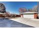 A detached brick garage in the backyard has an oversized concrete parking pad at 2921 E Colorado Ave, Denver, CO 80210