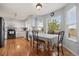 Bright kitchen featuring white cabinetry, stainless steel appliances, and an adjacent dining area with a large window showcasing the view at 7888 Canvasback Cir, Littleton, CO 80125