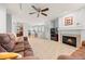 Open-concept living room with a fireplace, kitchen access, and comfortable seating at 7888 Canvasback Cir, Littleton, CO 80125
