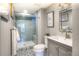 Modern bathroom featuring stylish vanity, framed mirror, and glass shower with blue tiling at 8140 S Storm King Peak, Littleton, CO 80127