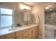Bright bathroom featuring double sinks with a marble counter, soft-toned cabinetry, and elegant tile flooring at 8140 S Storm King Peak, Littleton, CO 80127