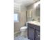 Charming half bathroom featuring a modern vanity, decorative mirror, patterned tile floor, and a bright window at 8140 S Storm King Peak, Littleton, CO 80127