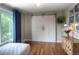 Inviting bedroom with hard wood flooring, sliding closet doors and an array of colorful paintings adorning the walls at 8140 S Storm King Peak, Littleton, CO 80127