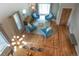 Bright living area with hardwood floors, multiple plush chairs, modern lighting, and a view of the dining space at 8140 S Storm King Peak, Littleton, CO 80127