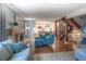 Open-concept living room with hardwood floors, stone fireplace, modern furnishings, and spiral staircase to the upper level at 8140 S Storm King Peak, Littleton, CO 80127
