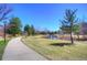Scenic walking path alongside a serene pond and lush greenery, offering a tranquil outdoor experience at 8140 S Storm King Peak, Littleton, CO 80127