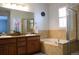 Bathroom with double sinks, soaking tub, and glass-enclosed shower at 11883 E Fair Ave, Greenwood Village, CO 80111