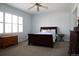 Bright bedroom with a large window, dark wood bed, and carpeted floors at 11883 E Fair Ave, Greenwood Village, CO 80111