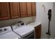 Laundry room with upper cabinets, a utility sink, and a front-load washer and dryer at 11883 E Fair Ave, Greenwood Village, CO 80111