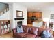 Warm living room with fireplace, adjacent kitchen, and comfortable furnishings at 11883 E Fair Ave, Greenwood Village, CO 80111