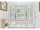 Bright white bathroom featuring a luxurious tub with mirrored walls and natural light at 6093 Willowbrook Dr, Morrison, CO 80465