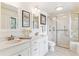 Bright bathroom with double sinks, a marble countertop, and a walk-in shower at 6093 Willowbrook Dr, Morrison, CO 80465