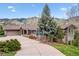 Spacious home exterior with a long driveway and mature landscaping, showcasing its curb appeal and serene setting at 6093 Willowbrook Dr, Morrison, CO 80465