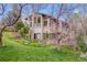 Charming exterior view of the home with mature trees, a well-maintained lawn, and beautiful architectural details at 6093 Willowbrook Dr, Morrison, CO 80465
