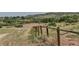 Scenic horse property featuring an enclosed riding area with fencing, set against a backdrop of rolling hills at 6093 Willowbrook Dr, Morrison, CO 80465