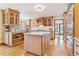 Bright kitchen with wood cabinets, large island, stainless appliances, and hardwood flooring creates a warm, inviting space at 6093 Willowbrook Dr, Morrison, CO 80465