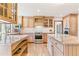 Bright kitchen with wood cabinets, stainless appliances, and hardwood flooring creates a warm, inviting space at 6093 Willowbrook Dr, Morrison, CO 80465