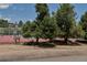 Private community tennis court surrounded by mature trees and greenery, providing a recreational space for residents at 6093 Willowbrook Dr, Morrison, CO 80465
