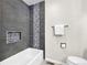 Nicely remodeled bathroom featuring modern tub, gray tiling, and toilet at 275 S Pembrook St, Castle Rock, CO 80104