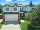 Charming two-story home boasts a manicured lawn, brick accents, and a two-car garage, nestled under a bright, partly cloudy sky at 275 S Pembrook St, Castle Rock, CO 80104