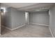 A finished basement room with neutral colors, wood-look tile, and white trim at 11645 Lincoln St, Northglenn, CO 80233