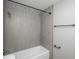 Bathroom featuring a shower with gray tile and a white bathtub at 11645 Lincoln St, Northglenn, CO 80233