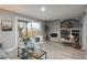 Comfortable living room with a stone fireplace, built-in shelving, and a sliding glass door to backyard at 11645 Lincoln St, Northglenn, CO 80233
