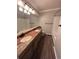 Bathroom featuring double sinks, wood floors, a shower and white subway tile to create a refreshing ambiance at 11506 Greenbriar Ln, Parker, CO 80138