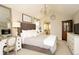 Elegant bedroom with tufted headboard, chandelier, and arched doorway at 11506 Greenbriar Ln, Parker, CO 80138