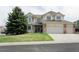 Charming two-story home with a well-manicured lawn and a large tree in front of the house at 11506 Greenbriar Ln, Parker, CO 80138