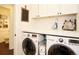 Clean laundry room with white cabinetry, solid surface countertops, and a front load washer/dryer at 11506 Greenbriar Ln, Parker, CO 80138