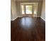 Bright living room featuring dark wood floors and a large bay window at 11506 Greenbriar Ln, Parker, CO 80138