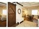 Cozy living area with a large sliding barn door, beamed ceiling, and comfortable seating at 11506 Greenbriar Ln, Parker, CO 80138