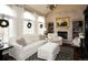 Bright living room with white furnishings, large windows, fireplace, and hardwood floors at 11506 Greenbriar Ln, Parker, CO 80138
