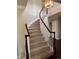 Elegant curved staircase with hardwood railing, carpeted steps, and a chandelier lighting the foyer at 11506 Greenbriar Ln, Parker, CO 80138